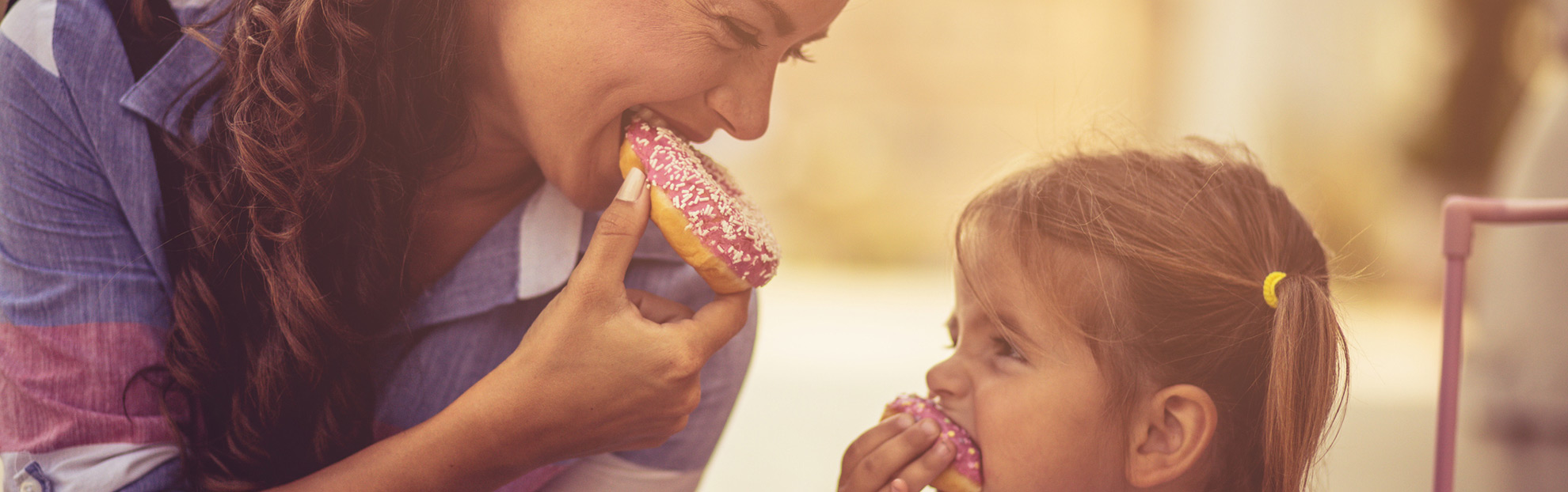 Arizona LASIK eye surgery patient happily eating donuts with her daughter