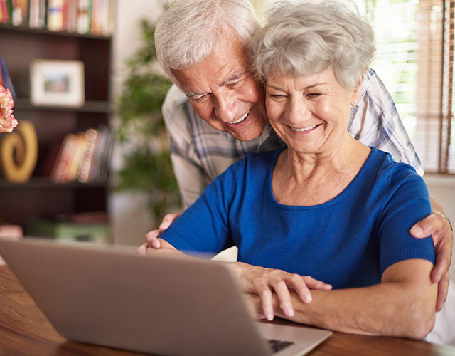 Older couple on laptop reading about the cost of cataract surgery