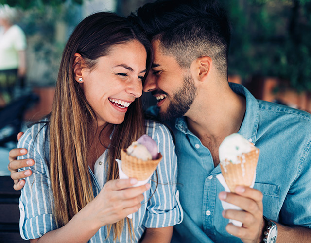 Happy couple eating ice-cream and enjoying clear vision after LASIK eye surgery