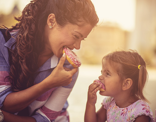 Happy LASIK eye care patient eating donuts with daughter