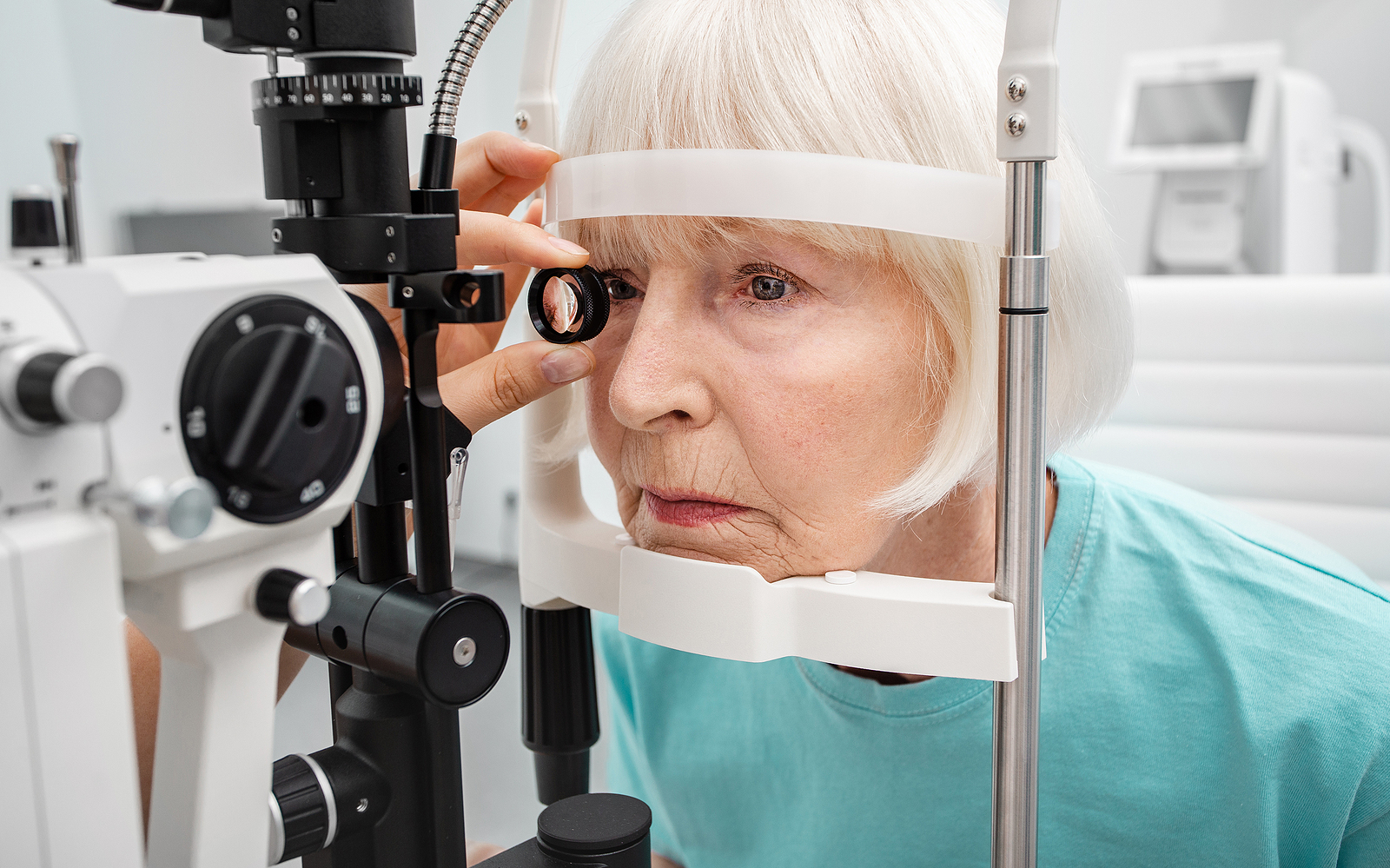 Senior woman eyesight test with binocular slit-lamp. Checking retina of a female eye close-up. Vision correction of elderly people
